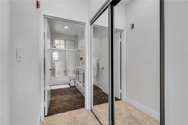 bathroom featuring baseboards and a shower with shower door