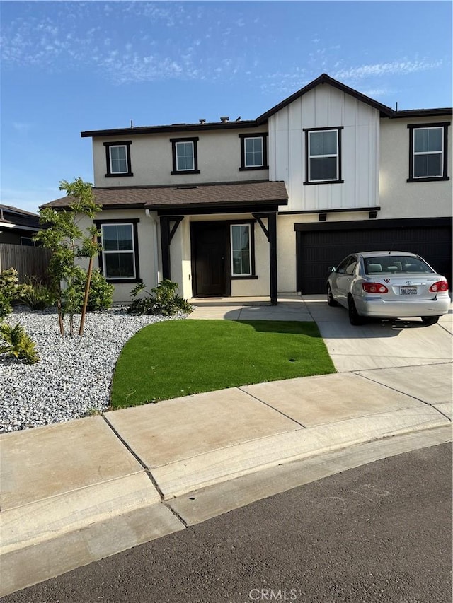 view of front facade with a front lawn, stucco siding, board and batten siding, concrete driveway, and an attached garage
