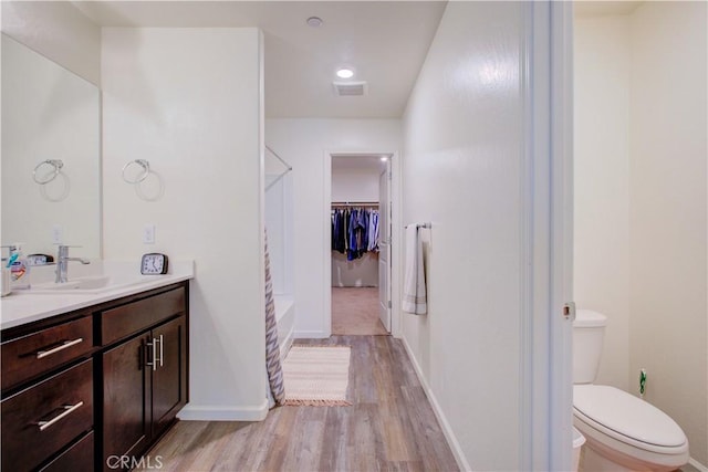 218 Bryce Canyon Ct, Merced, CA 95341 - bathroom with a shower, wood finished floors, toilet, vanity, and baseboards