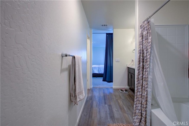 218 Bryce Canyon Ct, Merced, CA 95341 - full bath with wood finished floors, a textured wall, connected bathroom, baseboards, and shower / tub combo