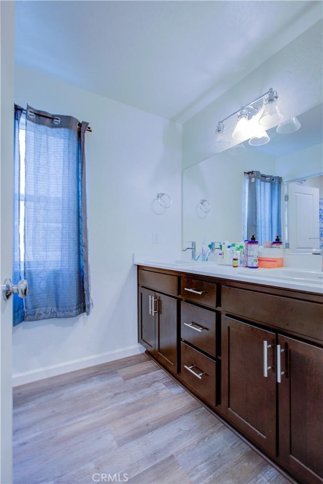 218 Bryce Canyon Ct, Merced, CA 95341 - bathroom with wood finished floors, double vanity, and baseboards