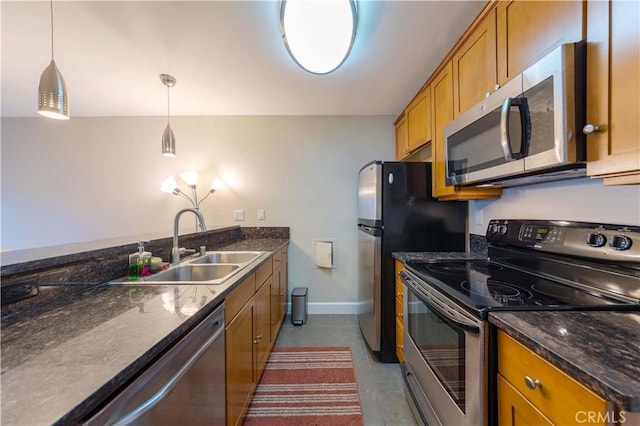 10982 Roebling Ave Unit 367, Los Angeles, CA 90024 - kitchen featuring stainless steel appliances, brown cabinetry, a sink, pendant lighting, and dark tile patterned flooring