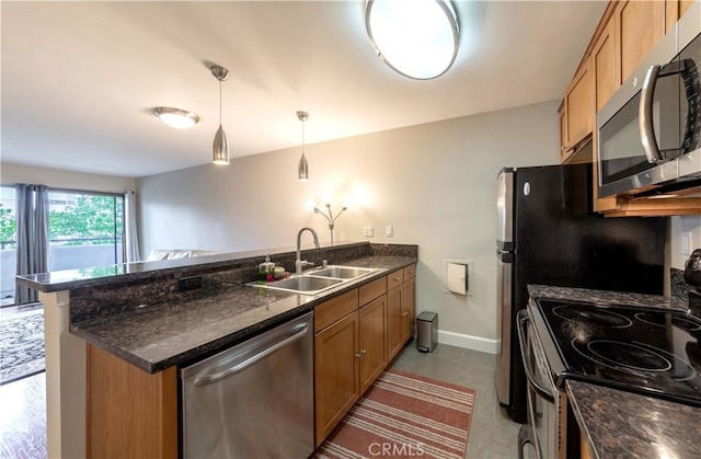 10982 Roebling Ave Unit 367, Los Angeles, CA 90024 - kitchen with stainless steel appliances, a sink, a peninsula, brown cabinets, and decorative light fixtures