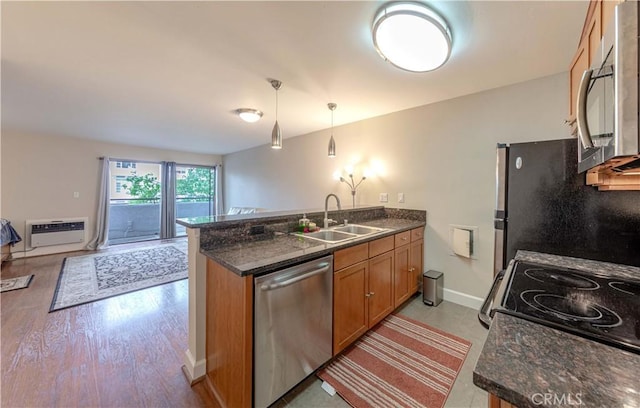10982 Roebling Ave Unit 367, Los Angeles, CA 90024 - kitchen featuring stainless steel appliances, a sink, a peninsula, brown cabinets, and baseboards