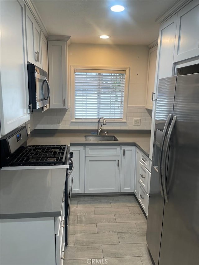 kitchen featuring recessed lighting, a sink, dark countertops, and stainless steel appliances
