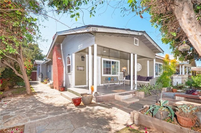back of house with a porch and fence