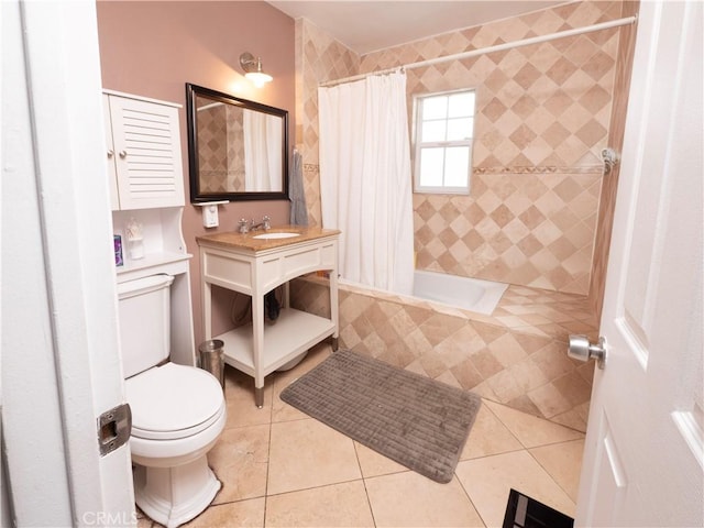 bathroom with toilet, tiled shower / bath, a sink, and tile patterned flooring