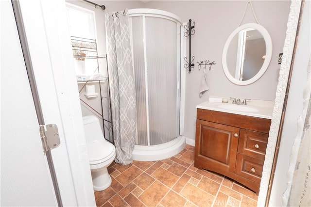 bathroom featuring vanity, a shower stall, and toilet