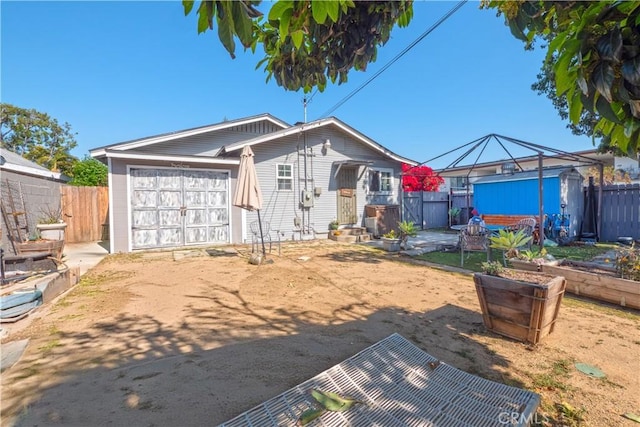 view of front of house featuring a garage, fence, dirt driveway, and a vegetable garden