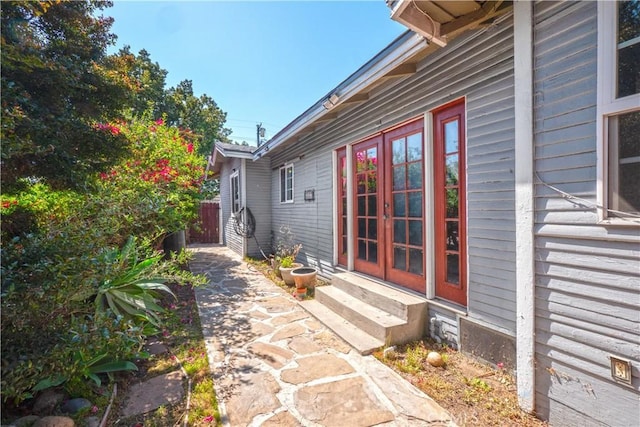 exterior space with entry steps, fence, and french doors