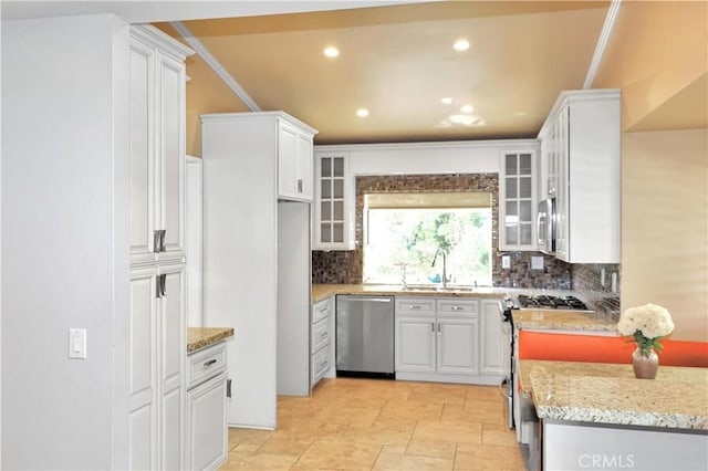 kitchen featuring a sink, backsplash, white cabinets, and appliances with stainless steel finishes