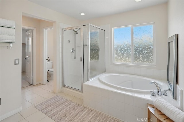 full bath with toilet, tile patterned floors, baseboards, a bath, and a stall shower