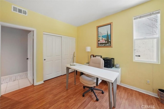 home office with baseboards, wood finished floors, and visible vents