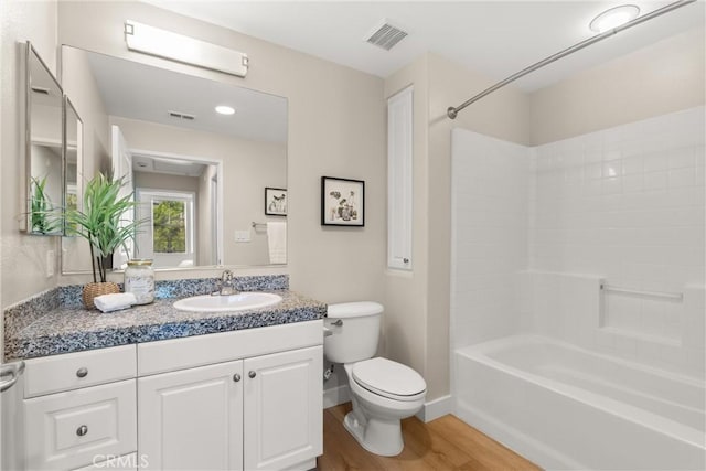 bathroom with toilet, visible vents, wood finished floors, and vanity