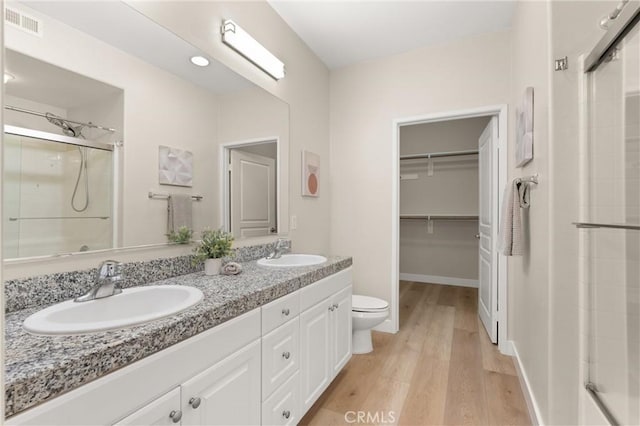 full bath with a shower stall, a sink, and wood finished floors