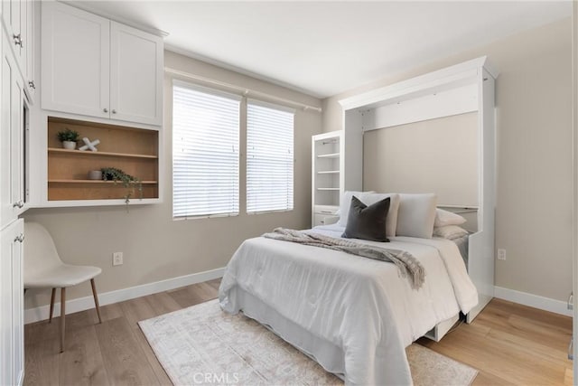 bedroom with baseboards and light wood-style flooring