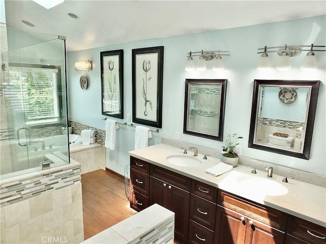 full bath featuring double vanity, a sink, a bath, and a shower stall