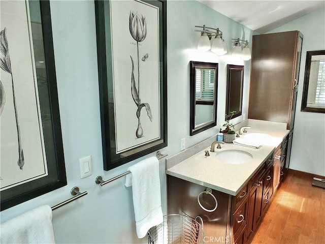 bathroom featuring double vanity, a sink, and wood finished floors