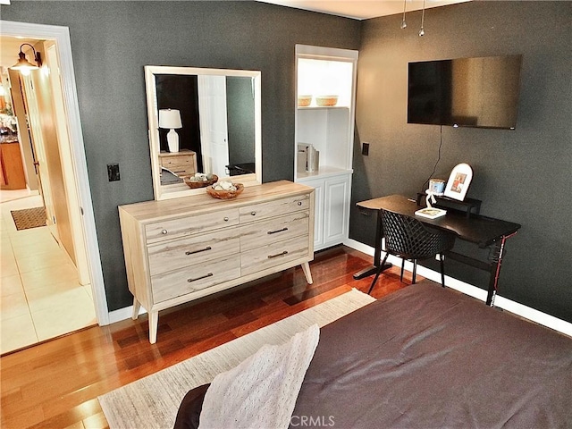bedroom with baseboards and dark wood-style floors