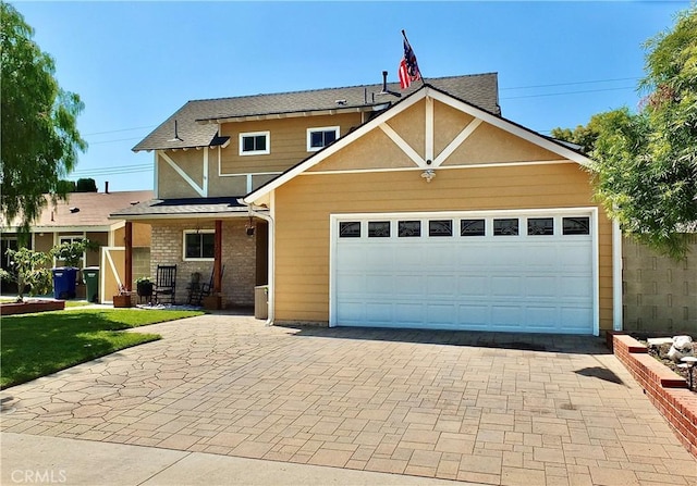 traditional home with an attached garage and decorative driveway