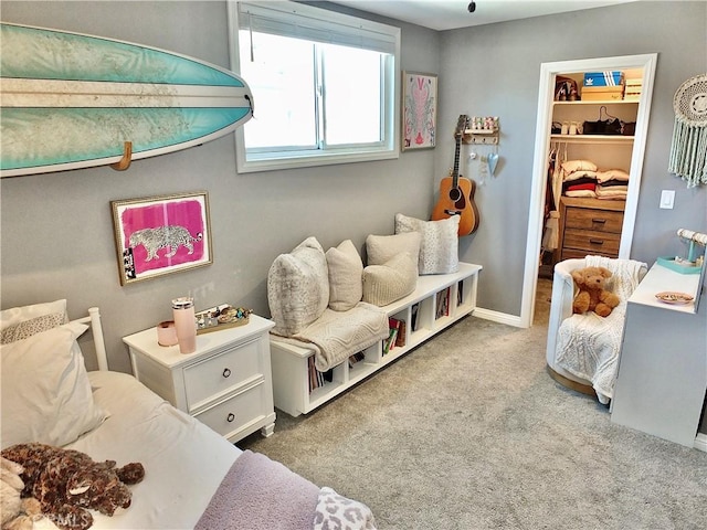 carpeted bedroom with a closet, baseboards, and a walk in closet