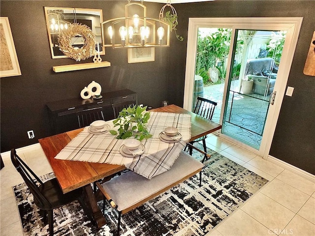 dining area featuring an inviting chandelier, baseboards, and tile patterned flooring