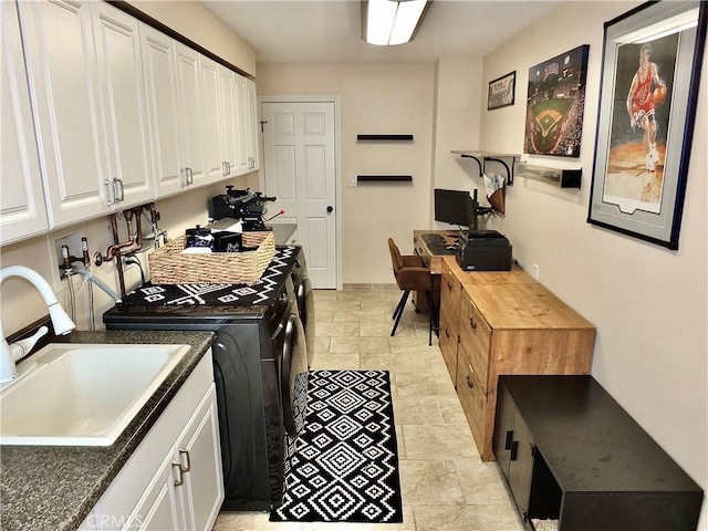 clothes washing area with a sink, stone finish floor, cabinet space, and washer and dryer