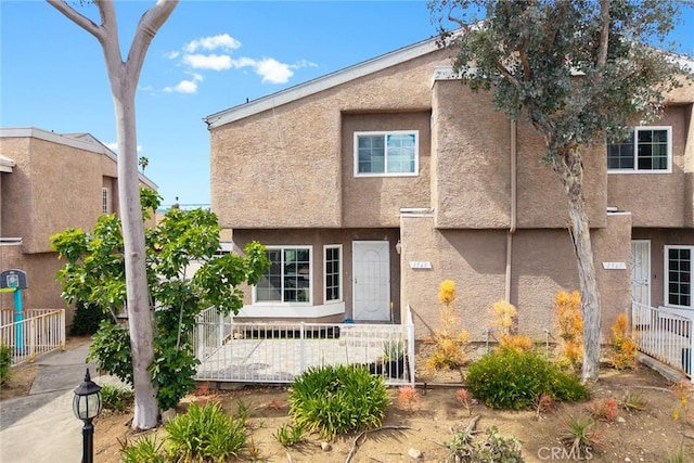 view of front of house featuring fence and stucco siding