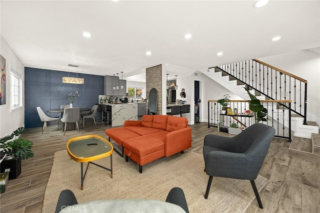 living room with light wood-style floors, recessed lighting, and stairway