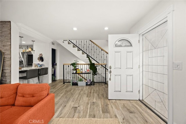 foyer entrance with visible vents, light wood-type flooring, stairs, baseboards, and recessed lighting