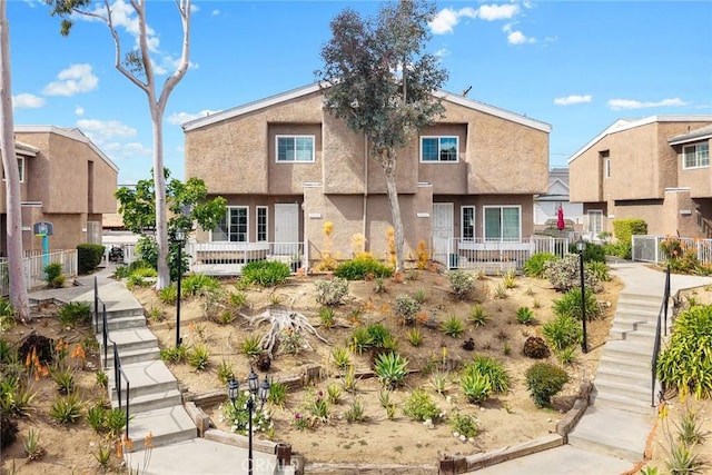 view of front of home with stairs and stucco siding