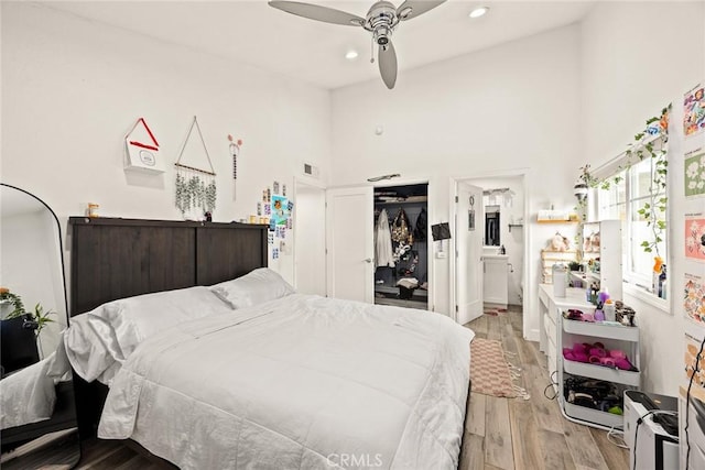 bedroom with visible vents, a closet, a high ceiling, recessed lighting, and light wood-style flooring
