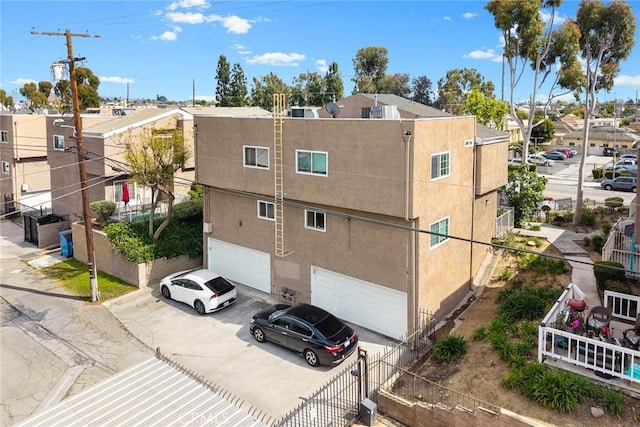 view of property with an attached garage, fence, a residential view, and concrete driveway