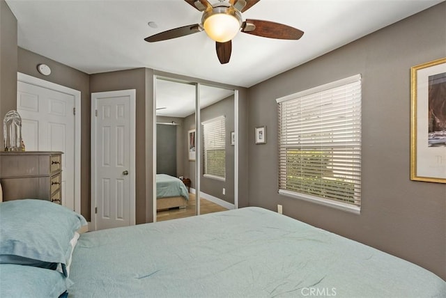 bedroom featuring a ceiling fan, baseboards, and wood finished floors