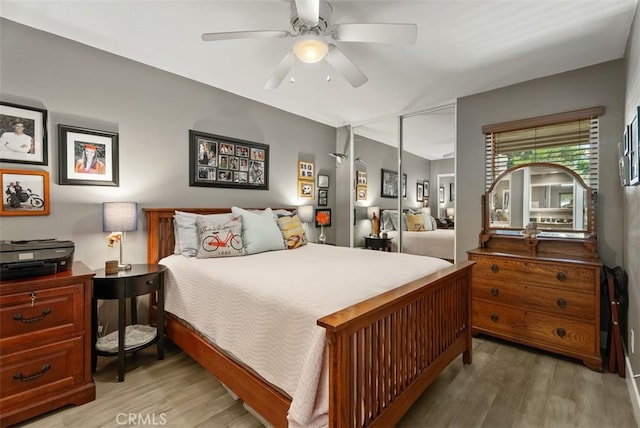 bedroom with a closet, a ceiling fan, and light wood-style floors