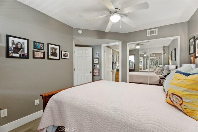 bedroom featuring visible vents, a closet, wood finished floors, baseboards, and ceiling fan