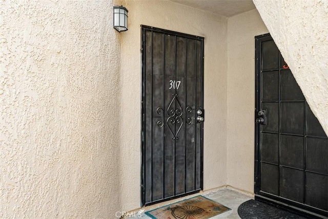 entrance to property with stucco siding
