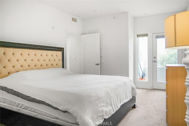 bedroom featuring access to outside, visible vents, and light carpet