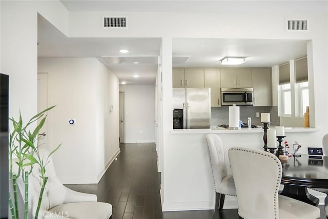 kitchen with baseboards, appliances with stainless steel finishes, decorative backsplash, and visible vents