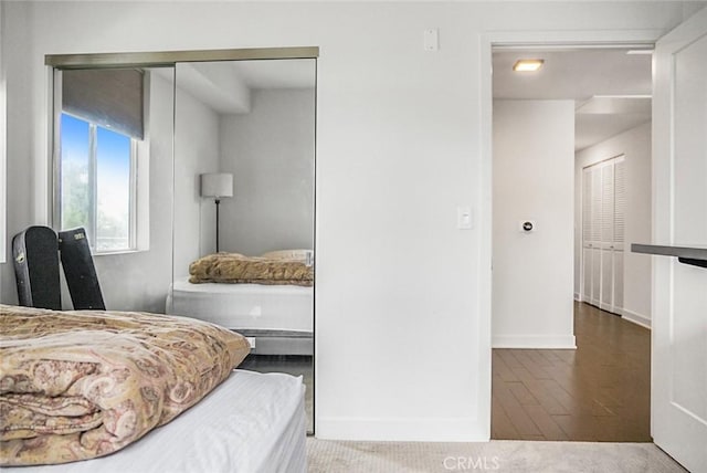bedroom with baseboards and wood finished floors