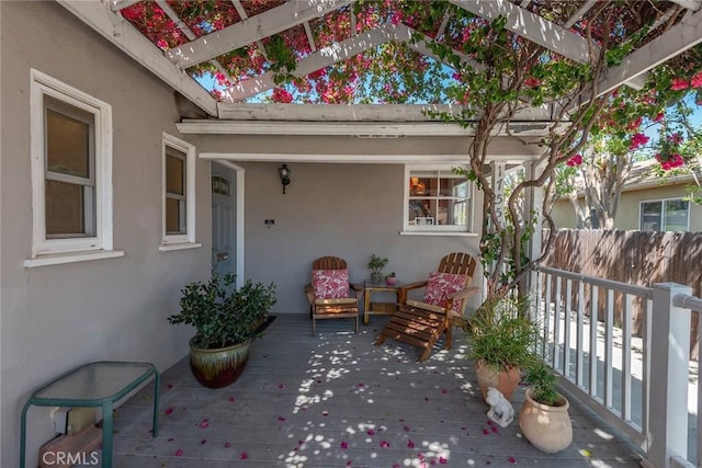 exterior space with a wooden deck, a pergola, and fence