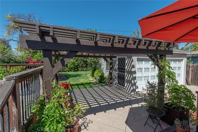 view of patio / terrace with a garage and a pergola