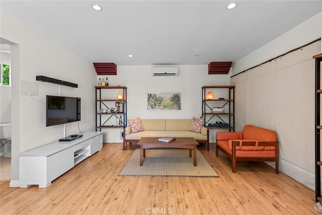 living area featuring light wood-style floors, a wall unit AC, and recessed lighting