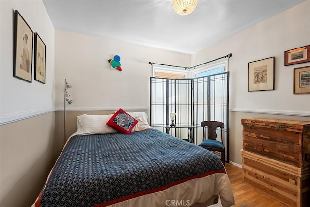 bedroom featuring baseboards and wood finished floors