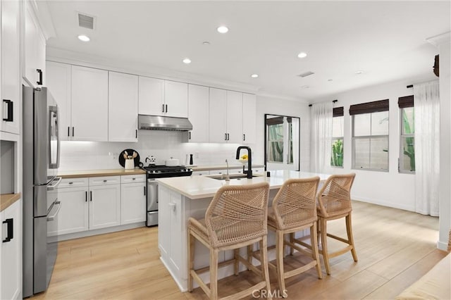 112 Gemstone, Irvine, CA 92620 - kitchen with appliances with stainless steel finishes, a sink, light countertops, under cabinet range hood, and visible vents