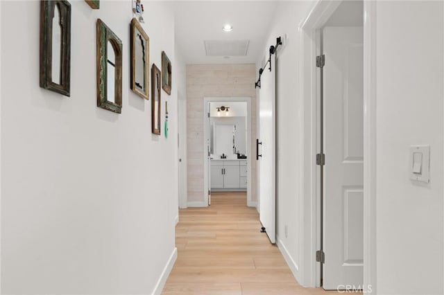 112 Gemstone, Irvine, CA 92620 - corridor with baseboards, light wood finished floors, a barn door, and visible vents