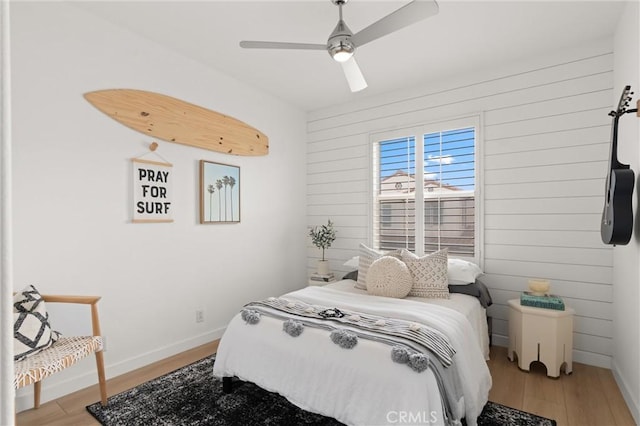 112 Gemstone, Irvine, CA 92620 - bedroom featuring baseboards, wood walls, ceiling fan, and light wood-type flooring
