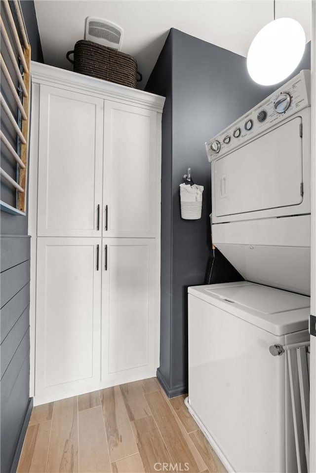 112 Gemstone, Irvine, CA 92620 - washroom featuring light wood-style floors, cabinet space, and stacked washer / dryer