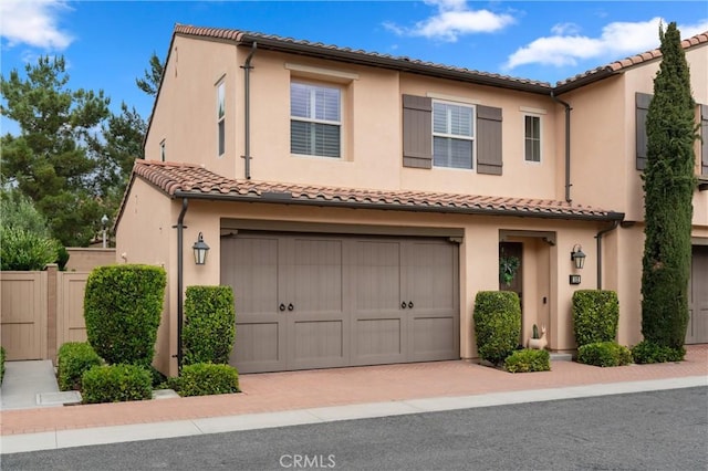112 Gemstone, Irvine, CA 92620 - view of front of house featuring fence, an attached garage, a tile roof, stucco siding, and decorative driveway