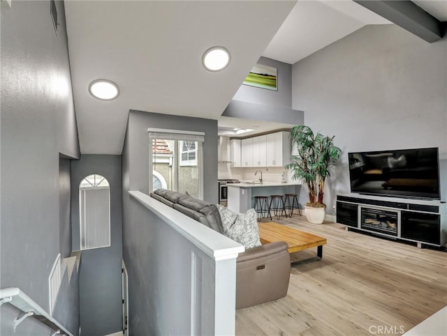 25081 Leucadia St Unit F, Laguna Niguel, CA 92677 - living room featuring lofted ceiling, light wood-style flooring, and baseboards